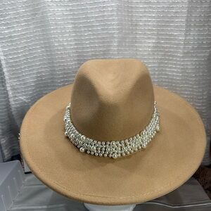 100% wool scoop fedora with a round neck
Tan beige hat with pearl trim
One size